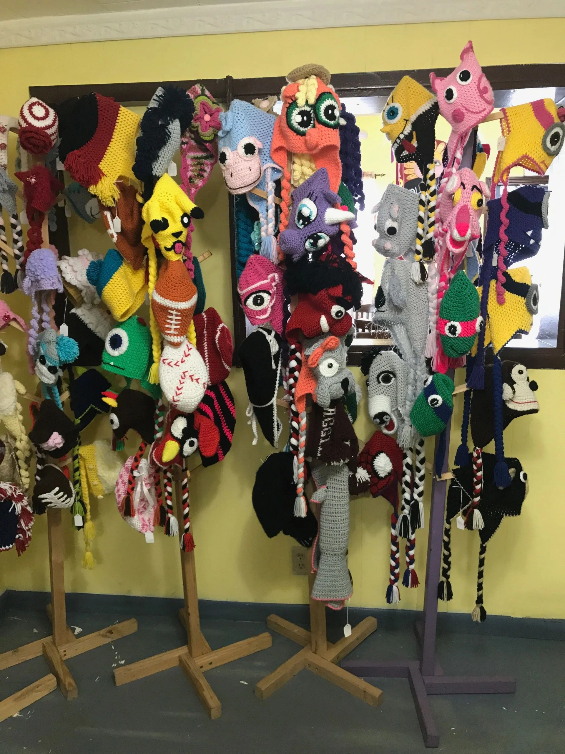 Chef Mila's handmade knitted animal hats on display stands in the bistro