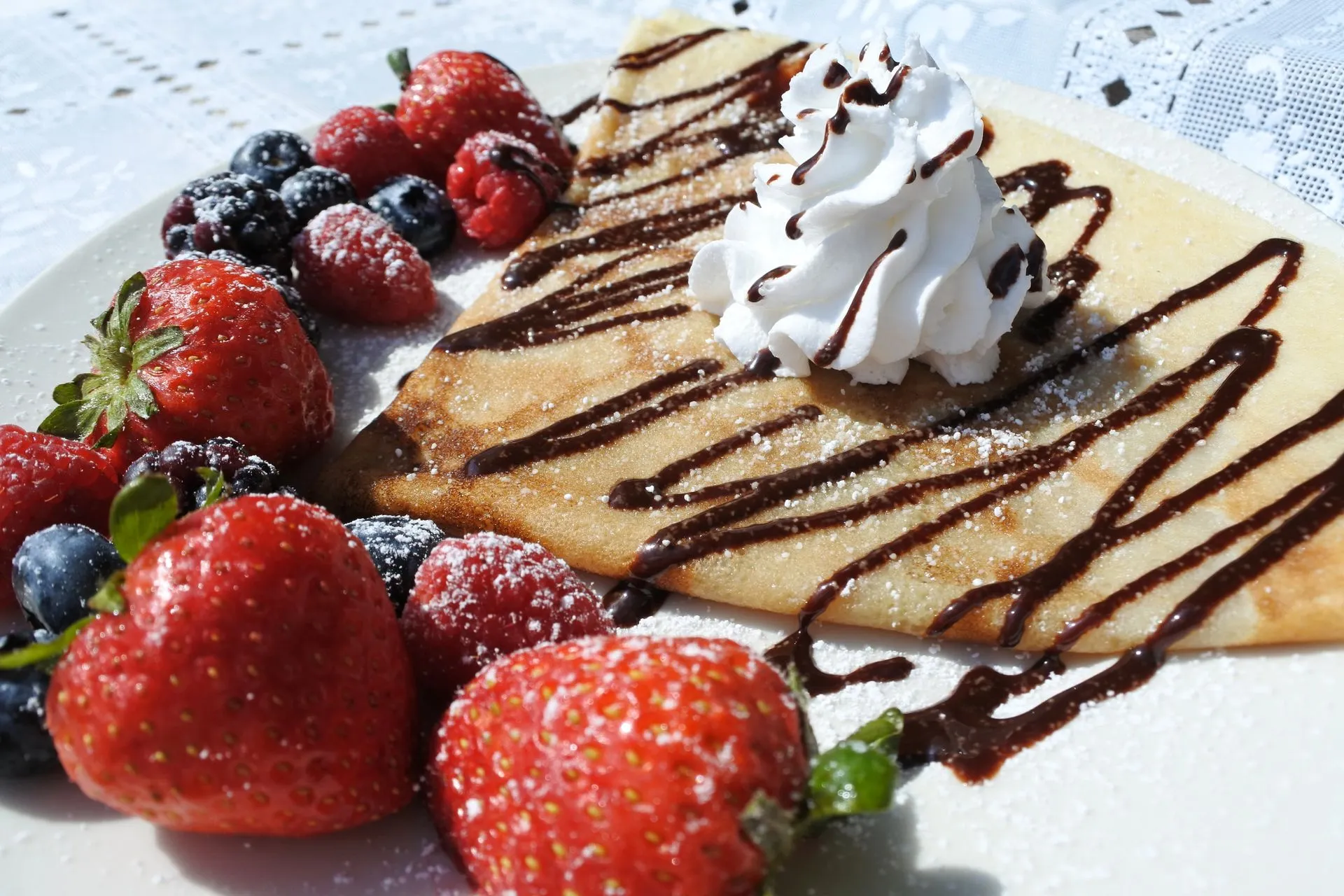 Sweet crepe topped with chocolate sauce and fresh berries